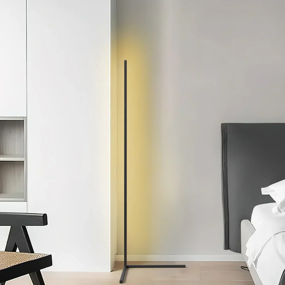 Schwarze Stehlampe mit gelbem Schein in heller Zimmerecke neben Bett und Holzstuhl 7