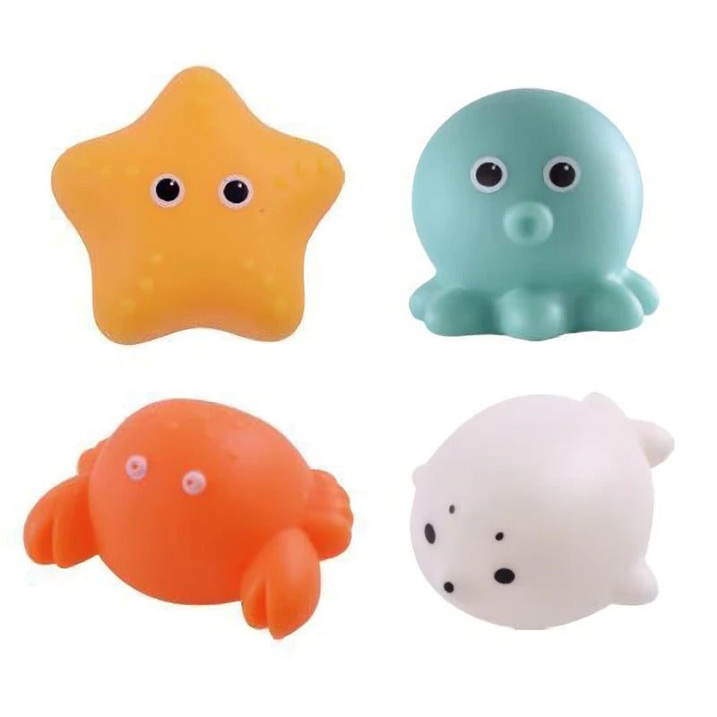 Vier bunte Baby-Badewannenspielzeuge: Seestern, Oktopus, Krabbe, Robbe, schwimmend, leuchtend.