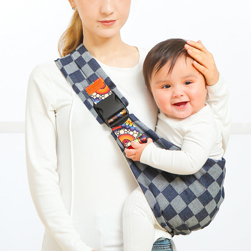 Frau mit Baby in kariertem Tragetuch, ergonomisch, blau-weiß, bequem, sicherheitsgeprüft.