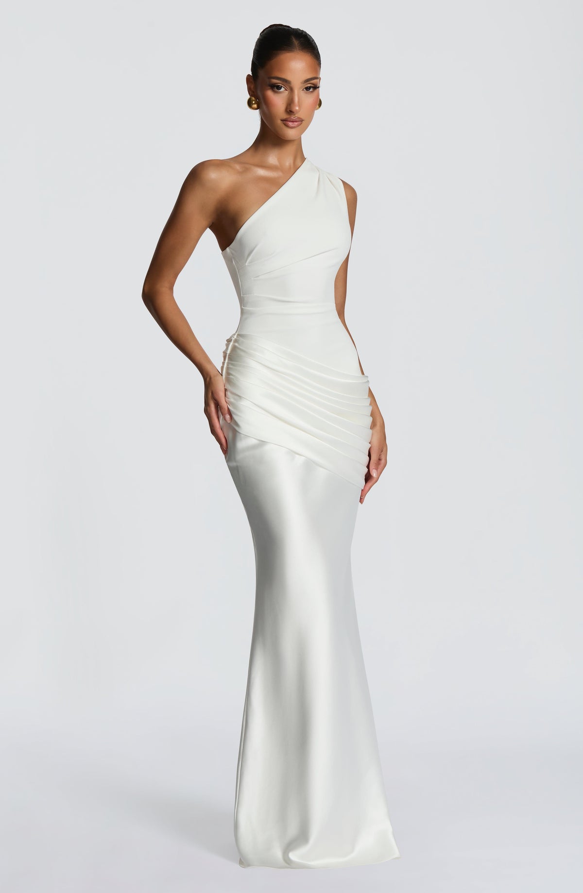 Seitliche Dreiviertelansicht des cremeweißen One-Shoulder-Kleides mit Raffung an der Hüfte und fließendem, bodenlangem Satinrock. 22