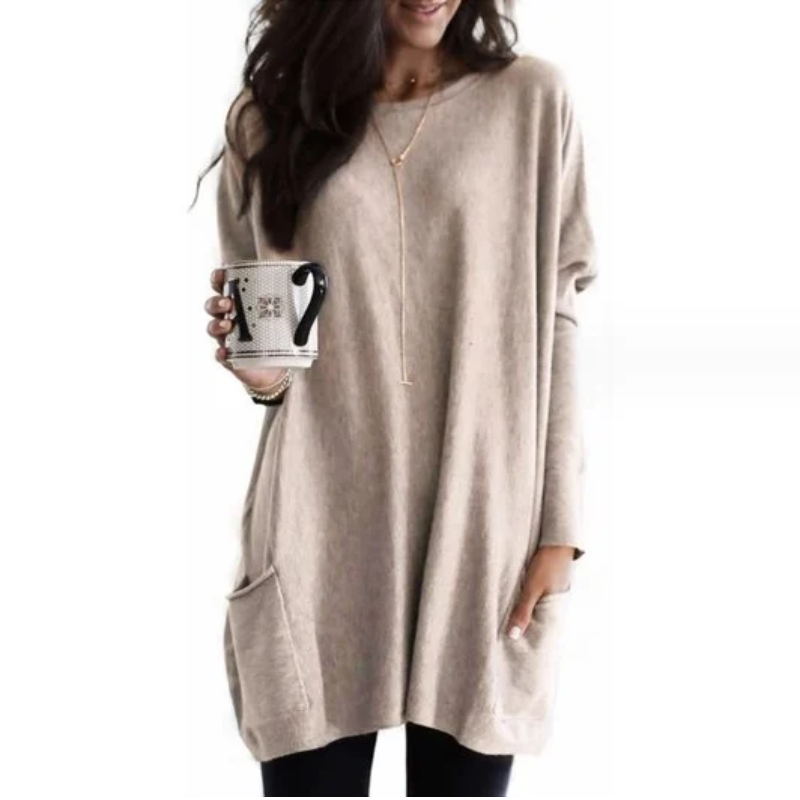 Frau in beigem Oversize-Pullover mit Tasse, lässige Mode, gemütlicher Look, Herbstkleidung.