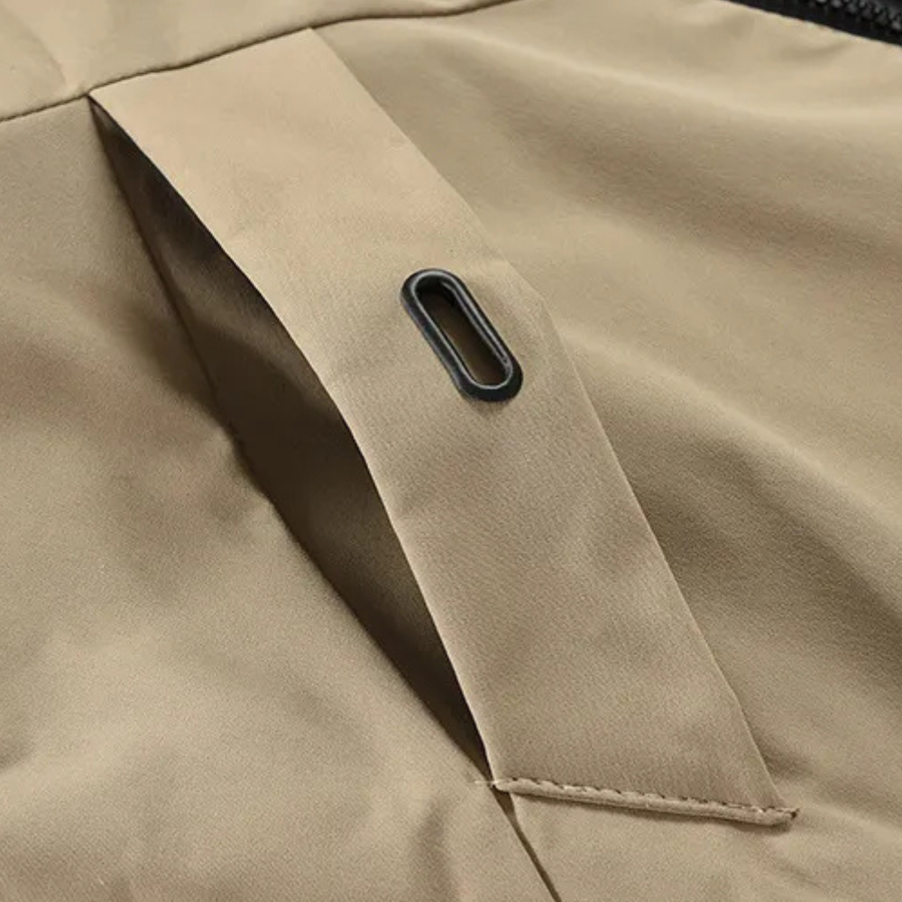 Beige Jacke Detailansicht, Reißverschluss, wetterfest, Outdoor-Bekleidung, hochwertige Verarbeitung.