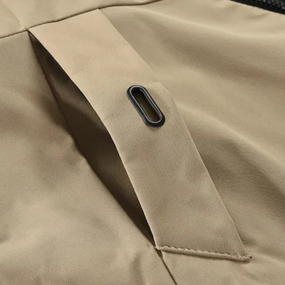 Beige Jacke Detailansicht, Reißverschluss, wetterfest, Outdoor-Bekleidung, hochwertige Verarbeitung.