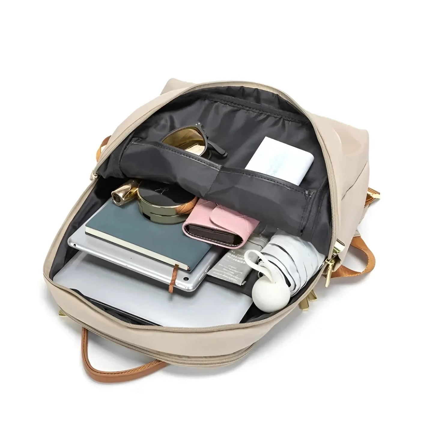Beiger Rucksack offen, gefüllt mit Laptop, Notizbuch, Kopfhörern, Ladegerät und Accessoires.