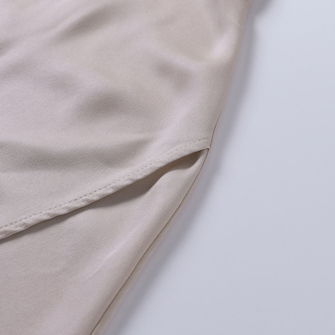 Beigefarbener Satin-Stoff, Nahaufnahme, weiche Textur, luxuriöses Material für Modekleidung.
