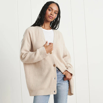 Frau trägt beige Strickjacke aus Wolle, lässiger Stil, modisch, gemütlich, Damenmode.