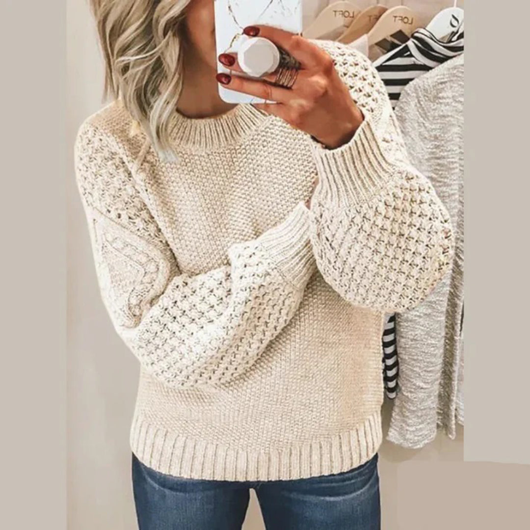 Frau in beigem Strickpullover mit Zopfmuster, lässig, modisch, Herbstmode, Damenbekleidung.