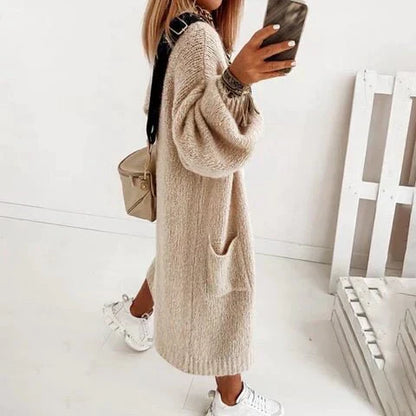 Frau in beiger Strickjacke, lässig, modisch, mit Tasche, weiße Sneaker, Herbstmode.