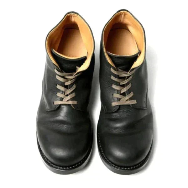 Braune Lederschnürstiefel von oben fotografiert, mit Blick auf die gekreuzte Schnürung, das helle Innenfutter und die abgerundete Kappe.