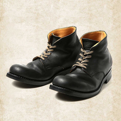 Braune Lederschnürstiefel in Schrägansicht mit hellen Schnürsenkeln und orangebraunem Lederfutter im Schaftinneren.
