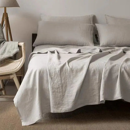 Graues Leinenbettwäsche-Set auf Doppelbett, modernes Schlafzimmer, skandinavisches Design.
