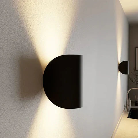 Seitenansicht einer schwarzen halbrunden Wandleuchte mit Licht nach oben und unten.