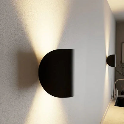 Seitenansicht einer schwarzen halbrunden Wandleuchte mit Licht nach oben und unten.