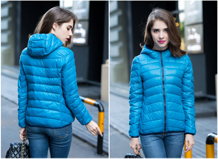Frau in blauer Daunenjacke, Kapuze, modisch, urbaner Hintergrund, Herbstmode.