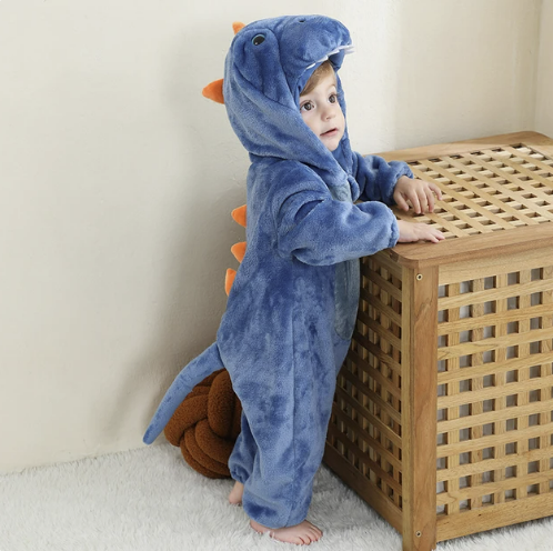Kleinkind im blauen Dinosaurier-Kostüm mit Kapuze und orangefarbenen Stacheln, Plüschmaterial.