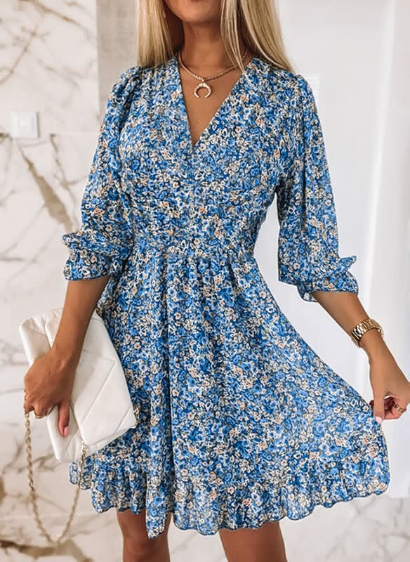 Frau in blauem Blumenkleid mit weißen Accessoires, elegantes Outfit, modisches Design.