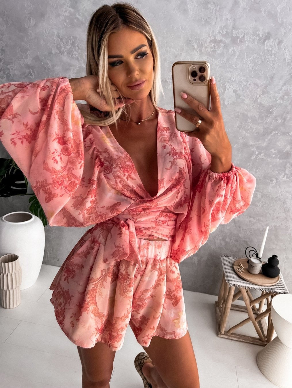 Frau in rosa geblümtem Kleid macht Selfie, modisches Outfit, Sommermode, Innenraum.