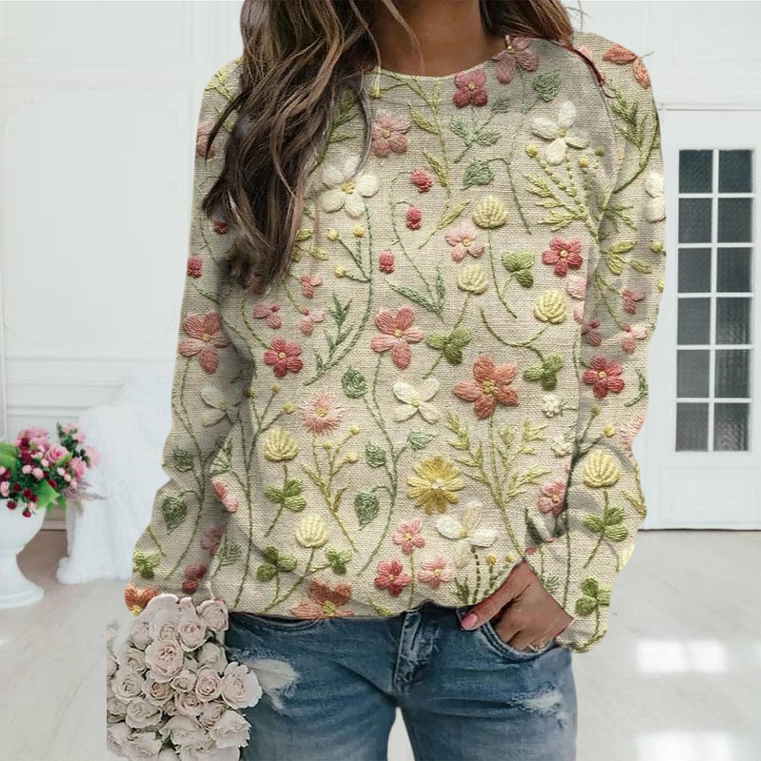 Frau in besticktem Blumenpullover, beige, lässig, modisch, Jeans, Blumenstrauß, Innenraum.