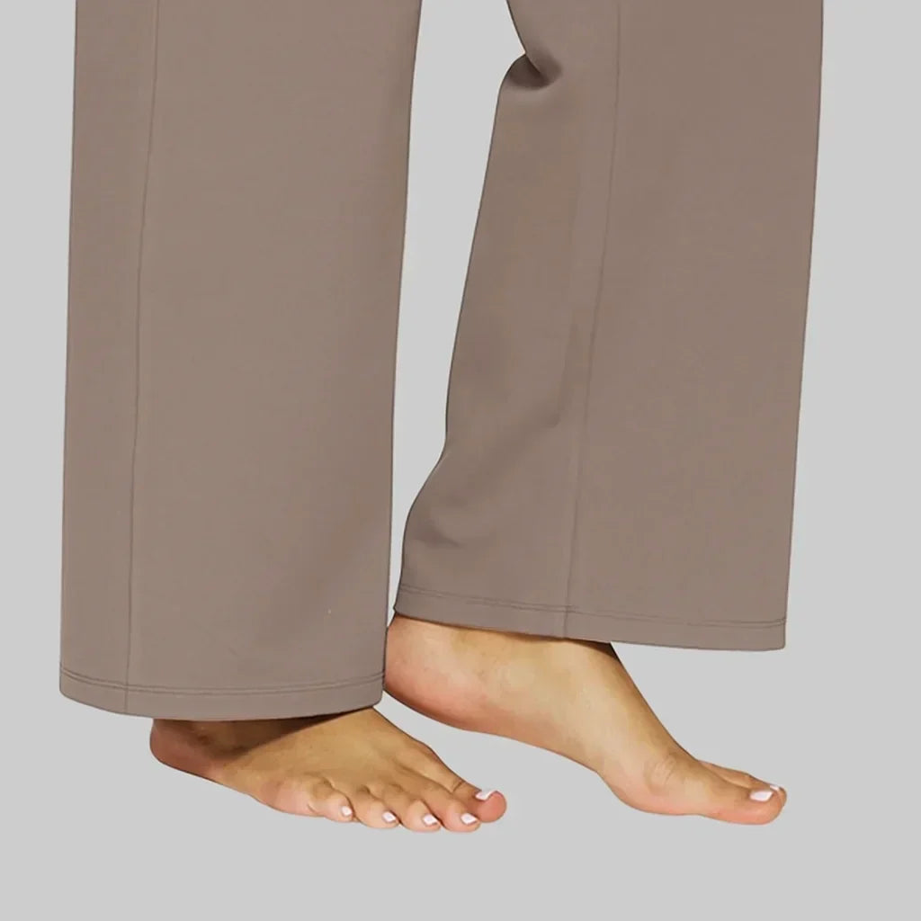 Detailaufnahme der unteren Beinabschlüsse der taupefarbenen Hose mit doppelter Saumnaht, barfüßig getragen. 5