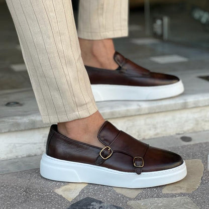 Braune Herren-Slipper mit Doppel-Gesp, handgefertigt, weißer Sohle, elegantes Design.