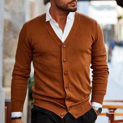 Mann in braunem Strick-Cardigan, weißem Hemd, schwarze Hose, stilvolle Herrenmode.