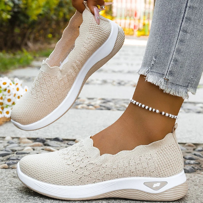 Ein beiger Slipper am Fuß, der andere in der Hand gehalten, innen und Sohle sichtbar 9