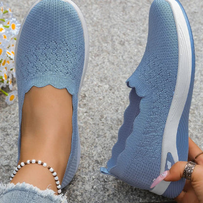 Blaue Slipper von oben, ein Schuh am Fuß, einer seitlich gehalten, Strickmuster erkennbar 16