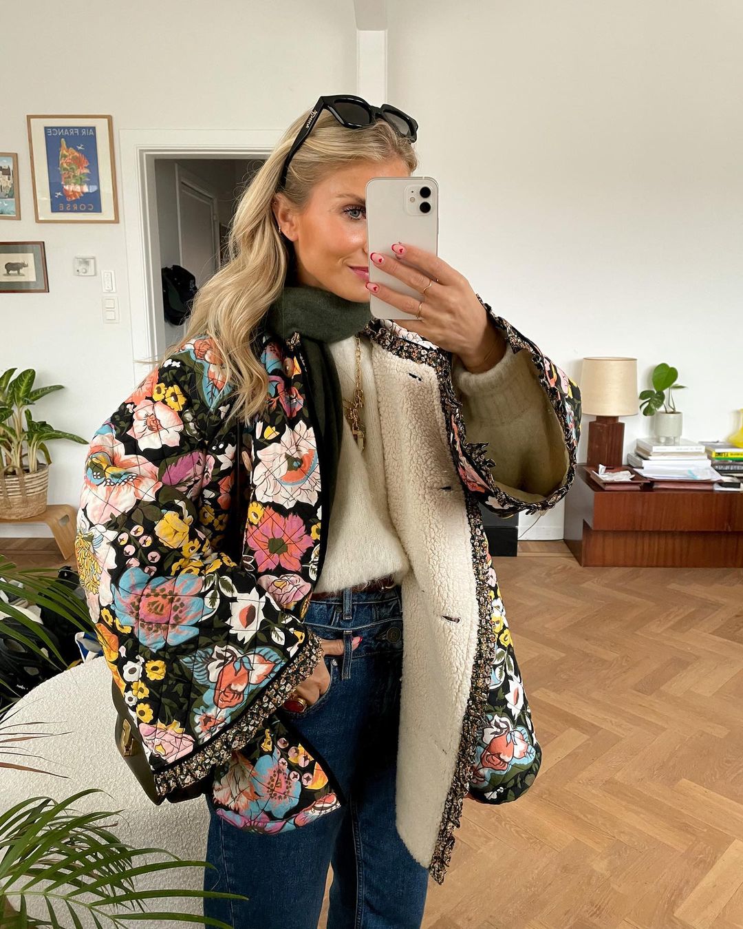 Frau im bunten Blumenmantel, weißem Pullover, blauer Jeans, Selfie, Wohnzimmer, Mode.