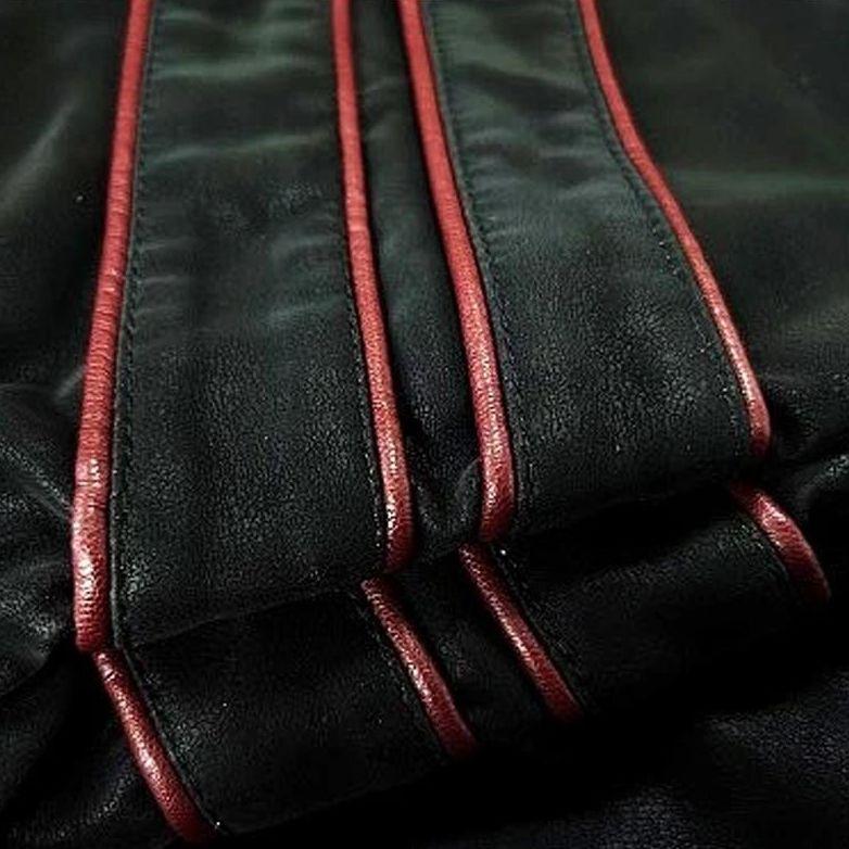 Schwarze Lederjacke mit roten Nähten, stilvolles Design, hochwertige Mode, Detailansicht.