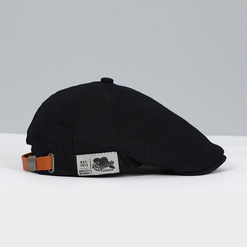 Schwarze Schiebermütze aus Baumwolle mit Lederband, stilvoll und zeitloses Design.