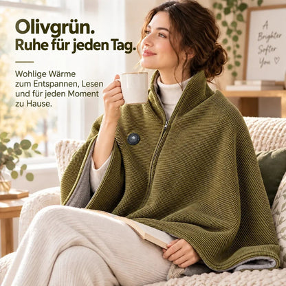 Frau auf dem Sofa in der olivgrünen Decke über den Schultern, mit Tasse und aufgeschlagenem Buch 8