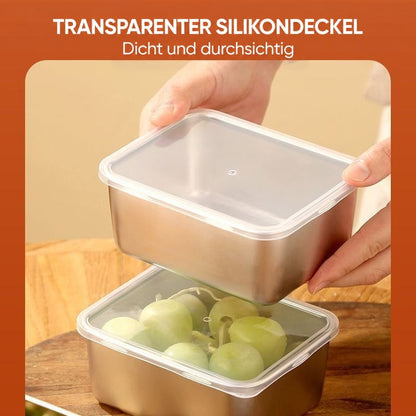 Hände setzen den durchsichtigen Silikondeckel auf eine Edelstahlbox mit Trauben, die untere Box ist bereits verschlossen. 9