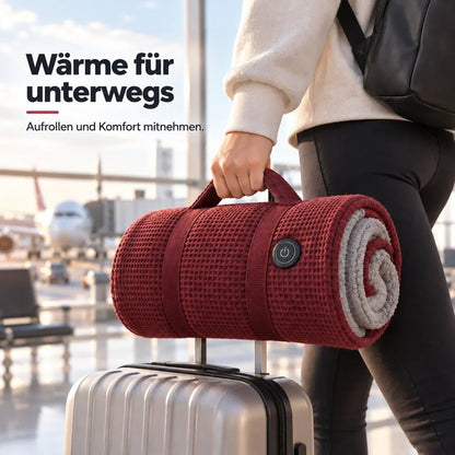 Zusammengerollte rote Decke mit Trageschlaufe und Gurten hängt am Griff eines Trolleys, von einer Frau getragen 2