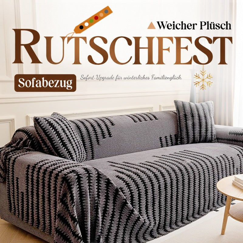 Graue Plüsch-Sofahusse mit schwarzem Zackenmuster auf einem Sofa mit passenden Kissen im hellen Wohnzimmer 1