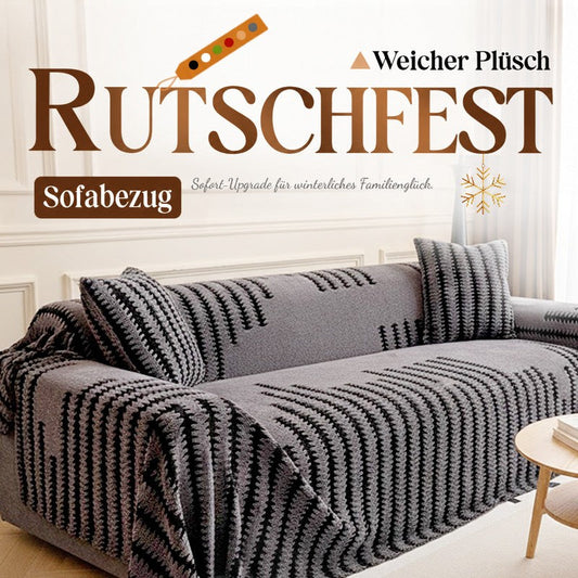 Graue Plüsch-Sofahusse mit schwarzem Zackenmuster auf einem Sofa mit passenden Kissen im hellen Wohnzimmer 1