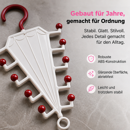 Nahaufnahme des weißen Hängers mit roten Kugelspitzen auf grauer Steinfläche, Detail von Haken und Oberfläche 3