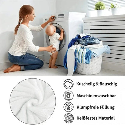 Mutter mit Kleinkind an der Waschmaschine, daneben Wäschekorb und Symbole zu Pflege und Eigenschaften der Decke 10