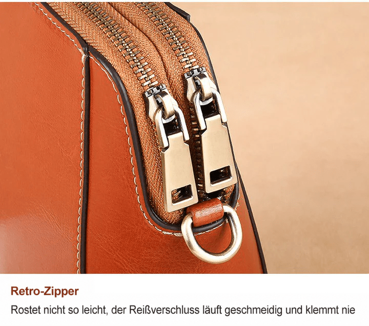 Nahaufnahme der beiden Reißverschlussläufer in Altmessing-Optik mit D-Ring an der braunen Tasche 13