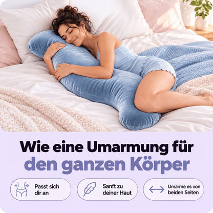 Frau liegt seitlich im Bett und umarmt das blaue Körperkissen mit Armen und Beinen 2