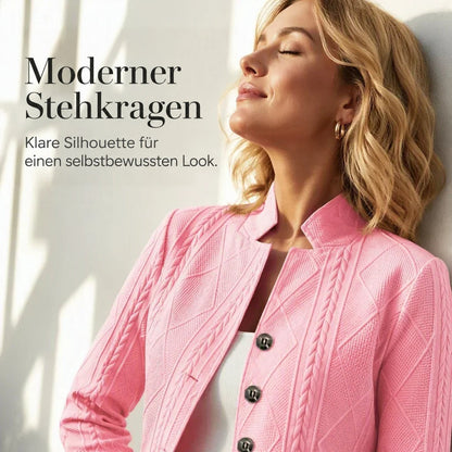 Frau im rosa Blazer mit Stehkragen lehnt mit geschlossenen Augen an einer Wand, Nahaufnahme von Kragen und Knöpfen. 19