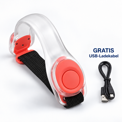 Transparentes Leuchtarmband mit roten Akzenten und schwarzem Band, daneben ein schwarzes USB-Ladekabel 1