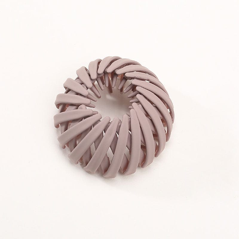 Matte Haarklammer in Altrosa mit spiralförmig angeordneten Rippen, einzeln vor hellem Hintergrund.
