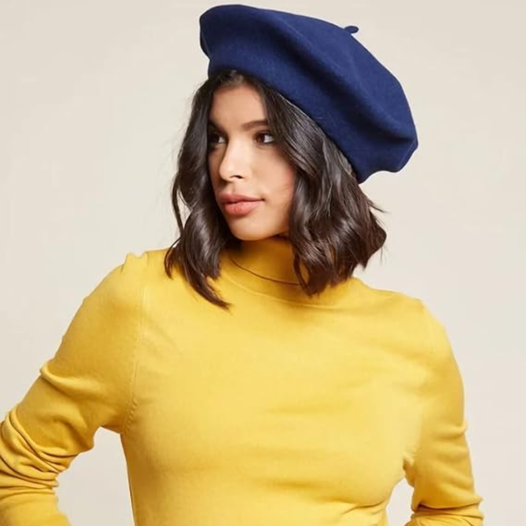 Frau mit dunklem Haar trägt ein marineblaues Beret zu gelbem Rollkragenpullover, Blick zur Seite 17