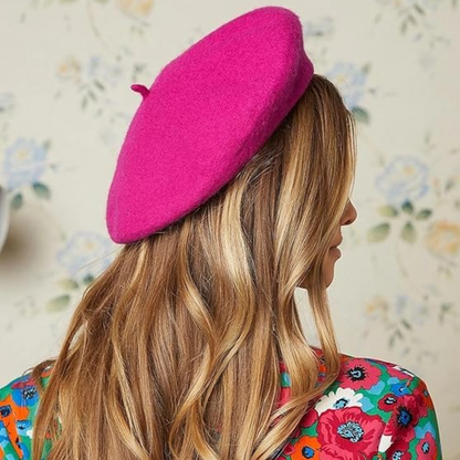 Rückansicht einer Frau mit langen Haaren, die ein pinkes Beret zu geblümtem Oberteil trägt 18