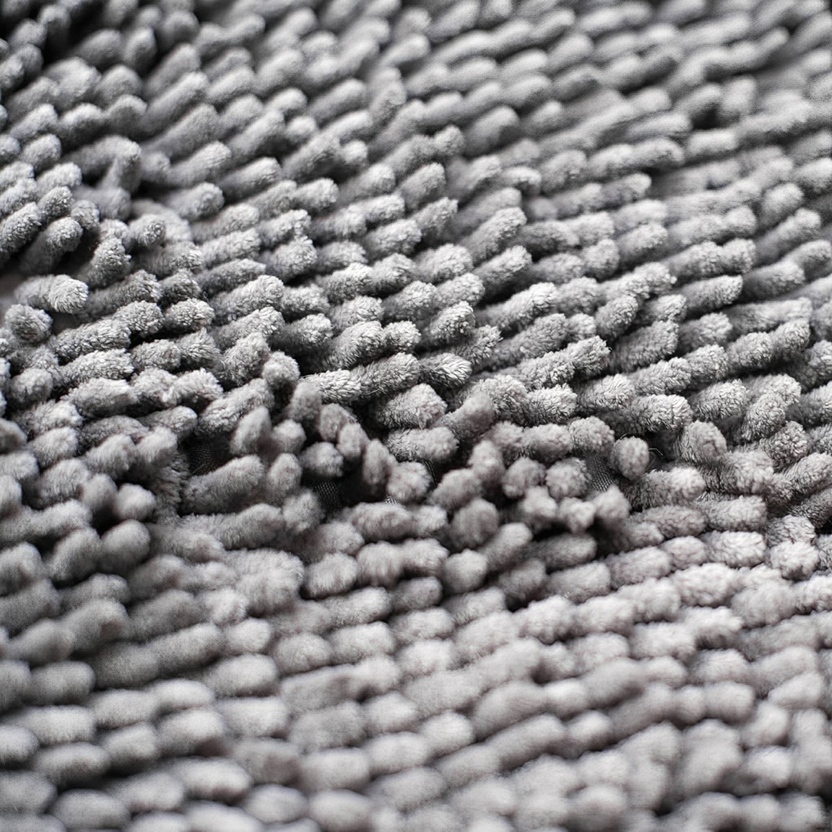 Graue Hundetürmatte aus Polyester mit dichter, weicher Oberflächenstruktur in Nahaufnahme.