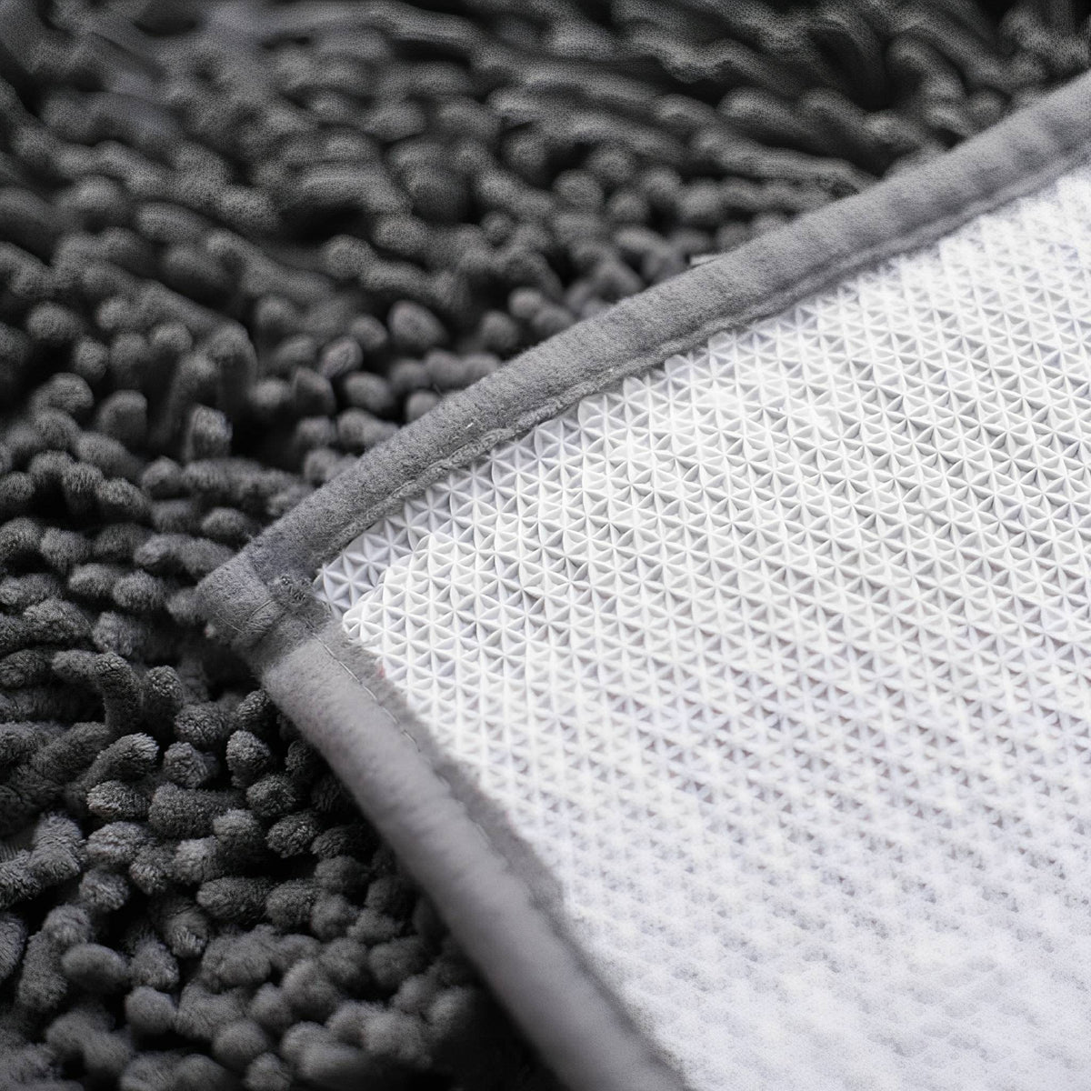 Graue Hundetürmatte aus Polyester mit umgeschlagener Ecke und rutschfester Rückseite.