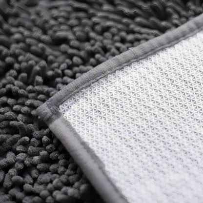 Graue Hundetürmatte aus Polyester mit umgeschlagener Ecke und rutschfester Rückseite.