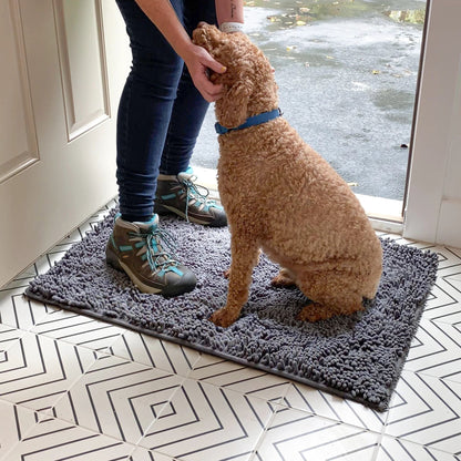 Graue Hundetürmatte aus Polyester mit Person, Hund und Wanderschuhen im Eingangsbereich.