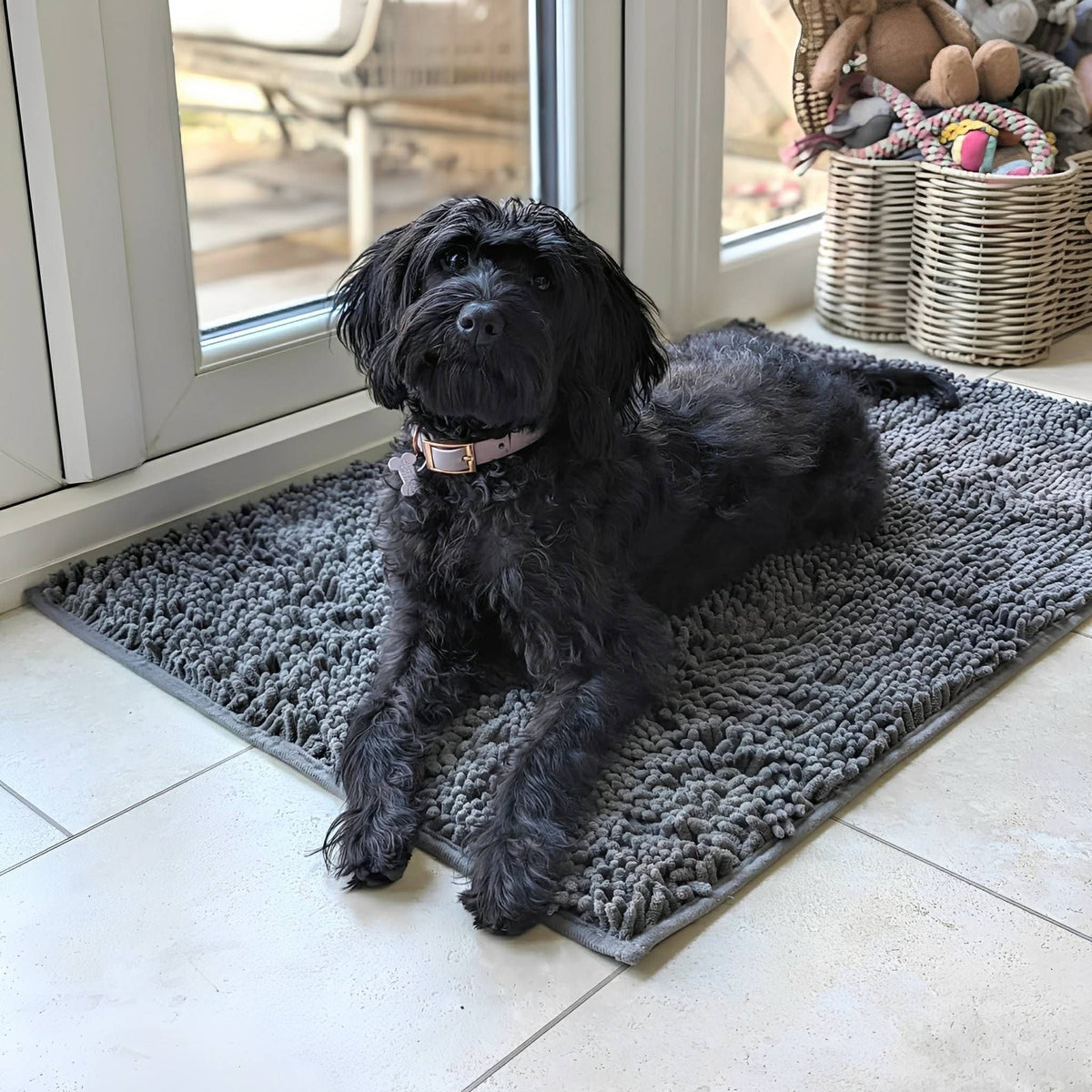 Graue Hundetürmatte aus Polyester mit Hund vor einer Terrassentür auf Fliesenboden.