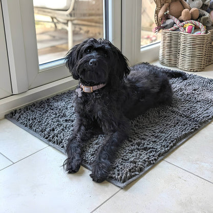 Graue Hundetürmatte aus Polyester mit Hund vor einer Terrassentür auf Fliesenboden.